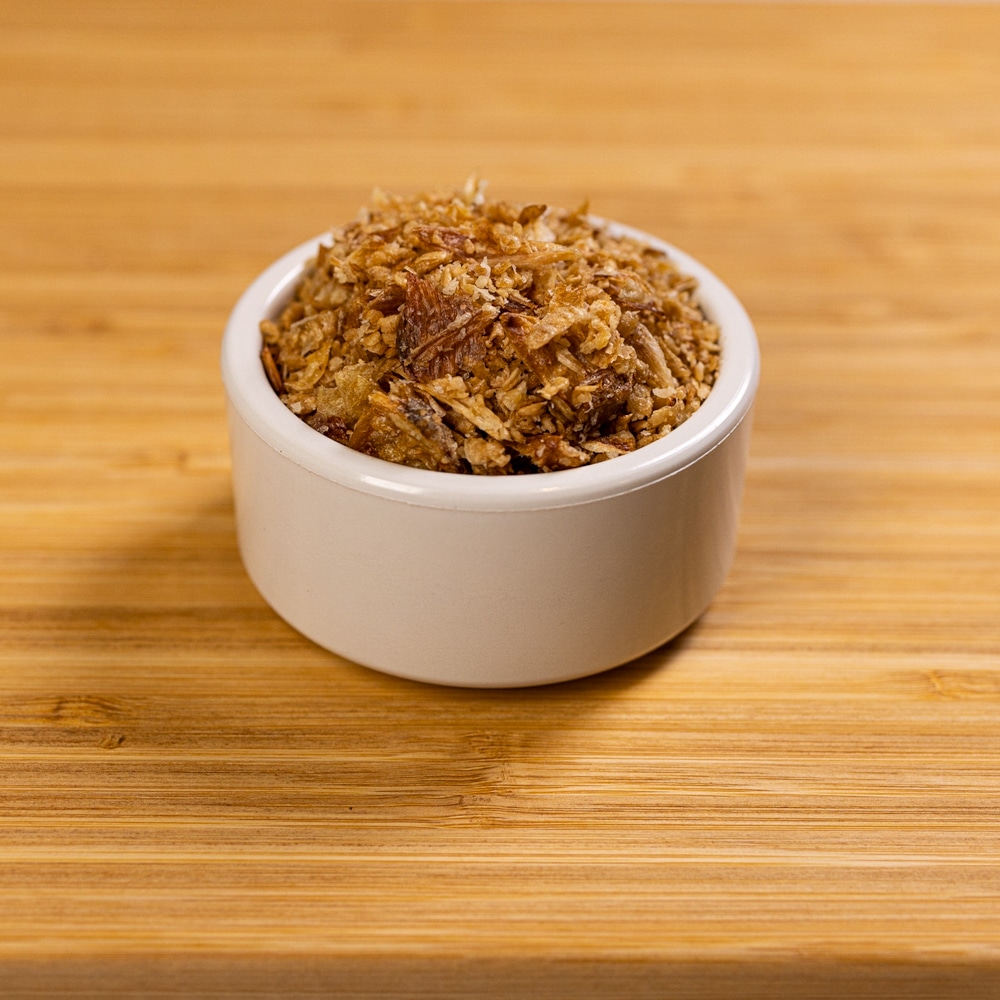 A bowl of granola sitting on top of a wooden table.