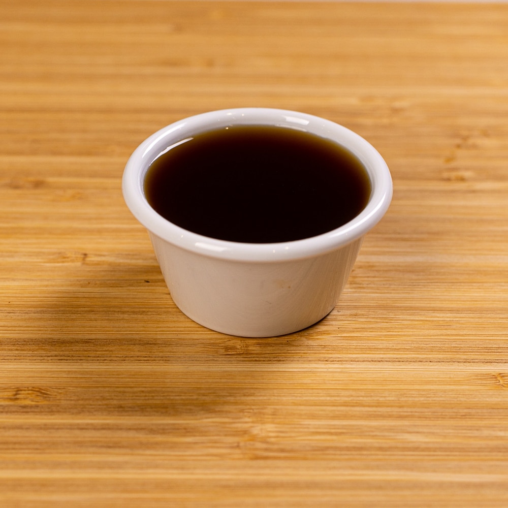 A white cup on a wooden table.